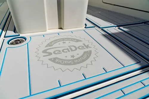 Close-up of a light gray SeaDek custom boat deck with blue trim and logo detail.
