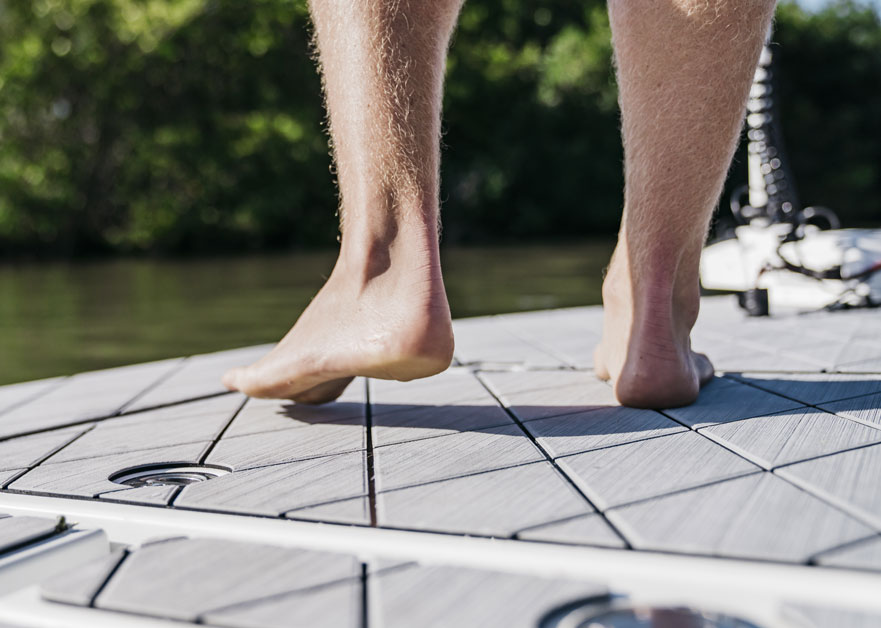 Bare feet standing on non skid SeaDek boat flooring for comfort and traction