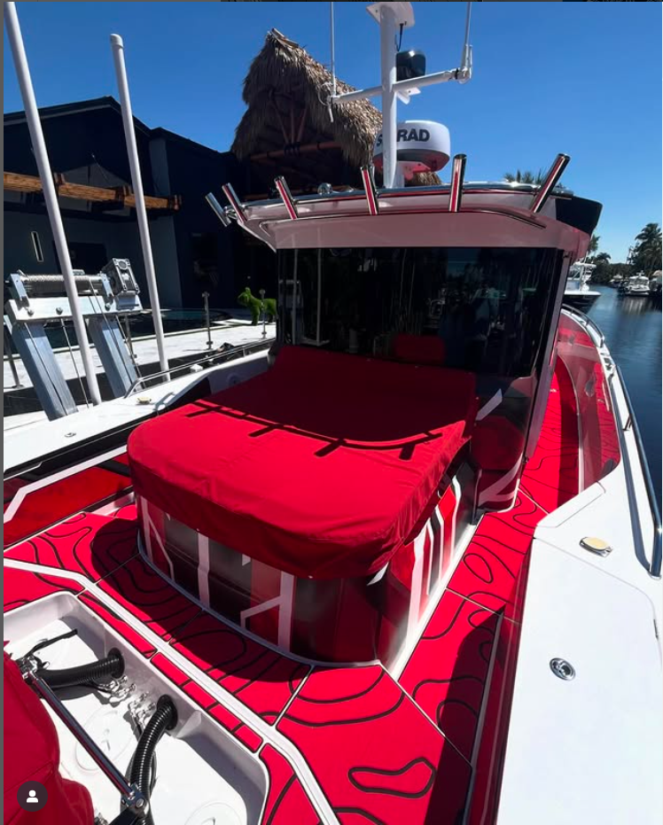 Boat with bright red custom SeaDek flooring and matching red canopy, showcasing bold color design for a standout look at the marina.