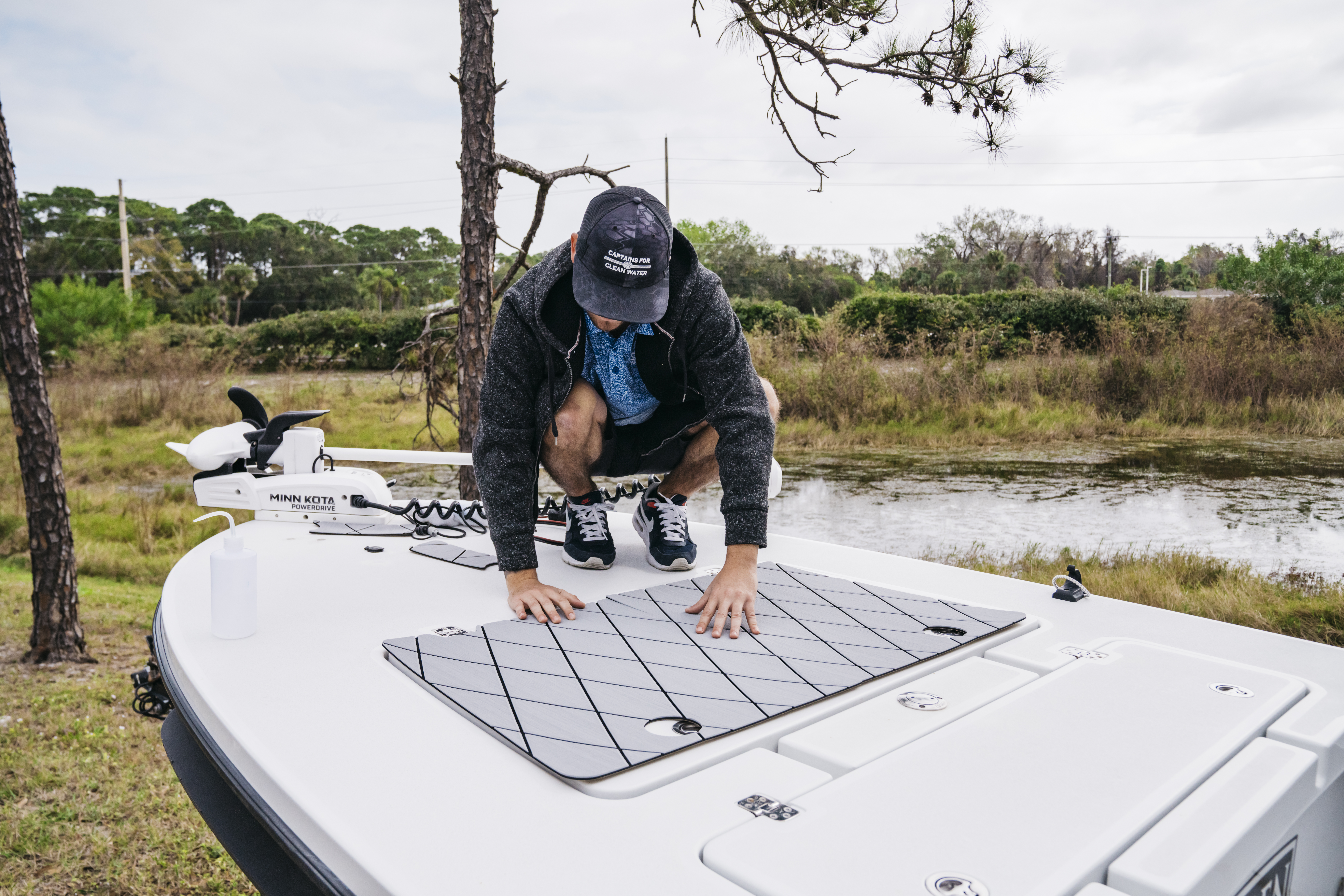 Boat flooring installers aligning SeaDek boat flooring panels during custom installation