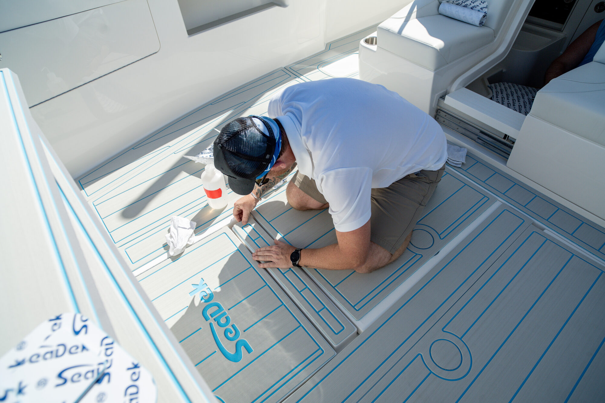 MarineDex technician installing custom SeaDek boat flooring with precision layout lines on a boat deck